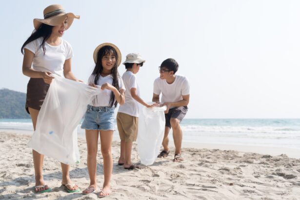 Asian Family volunteer picking up a plastic bottle on a beach with a sea to protect an environment